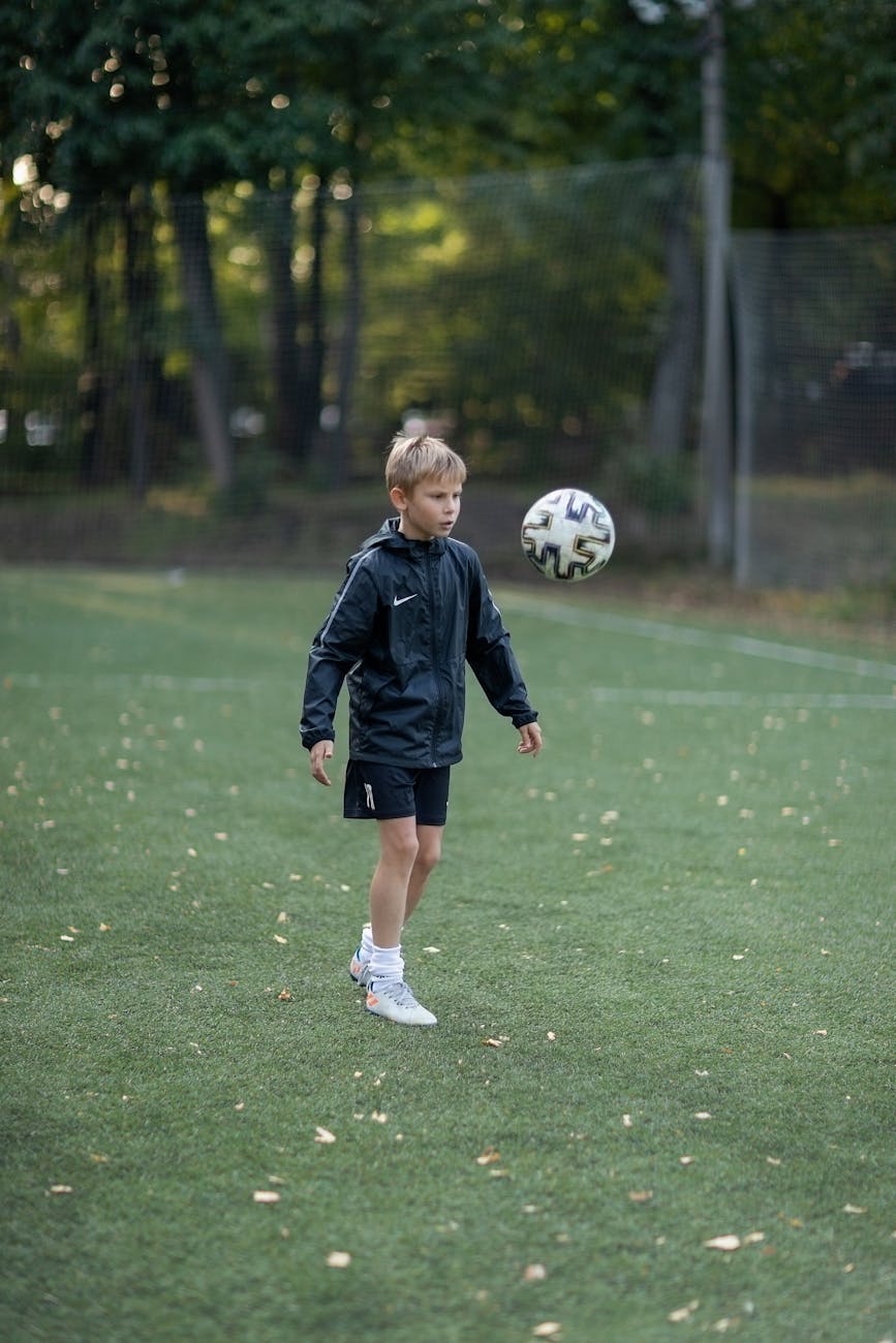 boy wearing jacket playing soccer